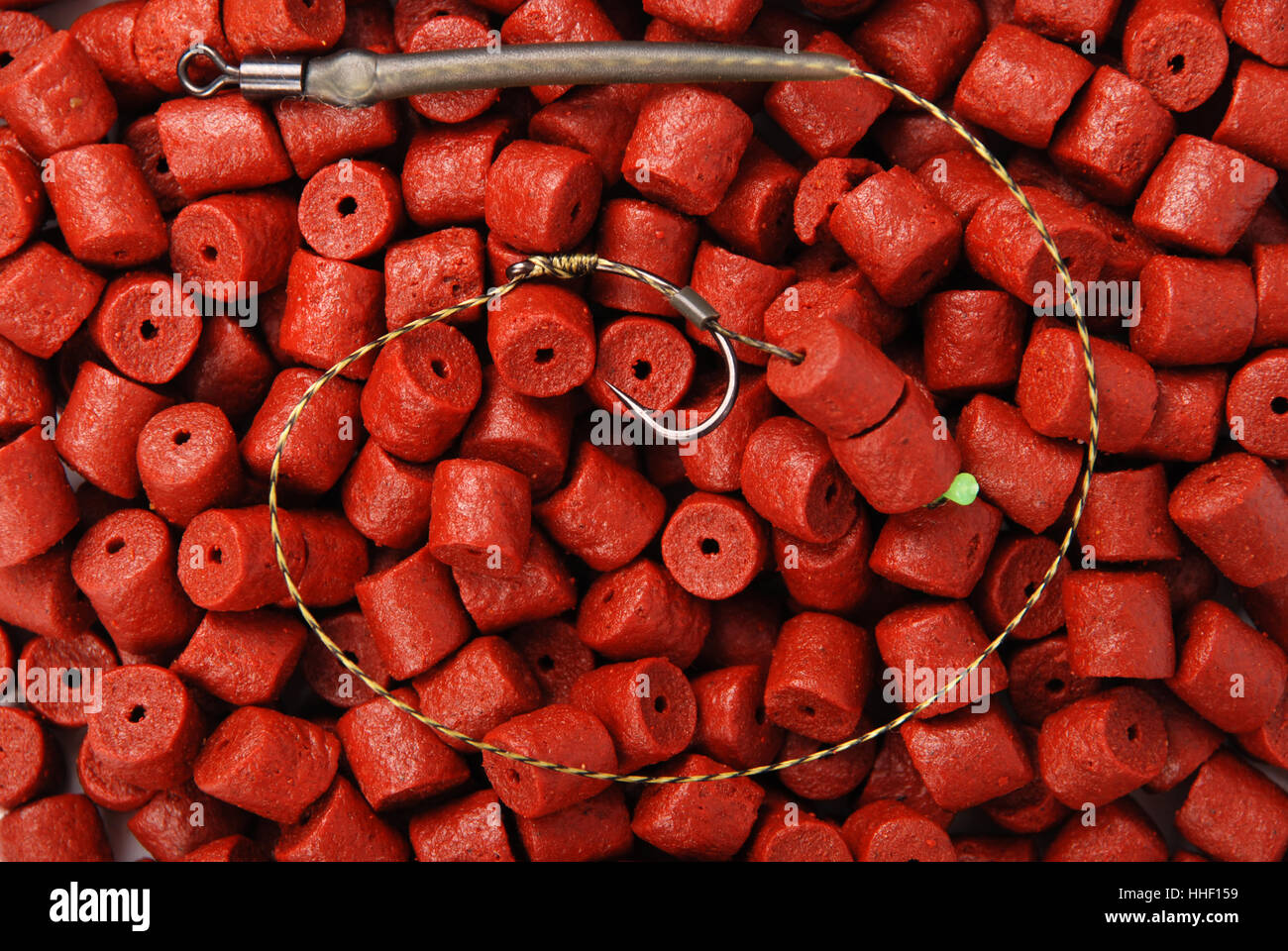 Esche da pesca con gancio sul rosso pre-forato halibut pellets per la pesca  alla carpa sfondo Foto stock - Alamy