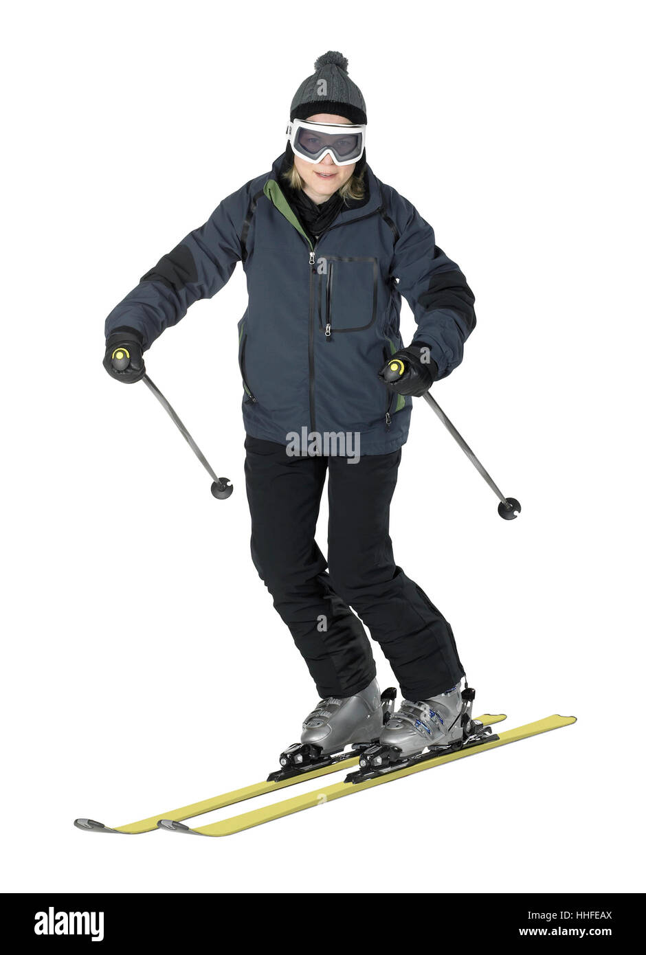 Tutto il corpo colpo di un vestito scuro sorridente ragazza durante la pratica dello sci, isolato su bianco Foto Stock