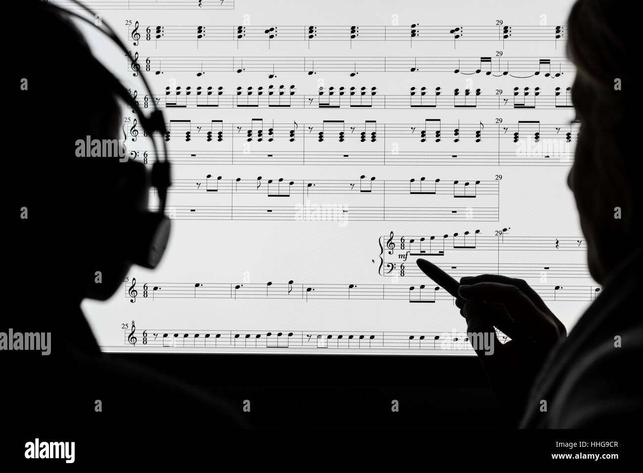 Due persone che lavorano su uno spartito musicale utilizzando computer software di notazione. Non è un vero e proprio cliente, note casualmente tratte dal fotografo. Foto Stock