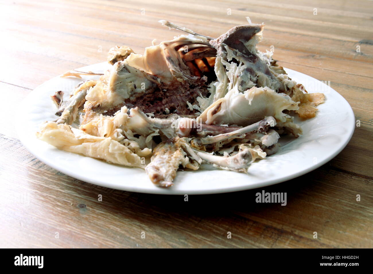 Pollo arrosto carcassa rimane su una piastra su un tavolo di legno Foto Stock