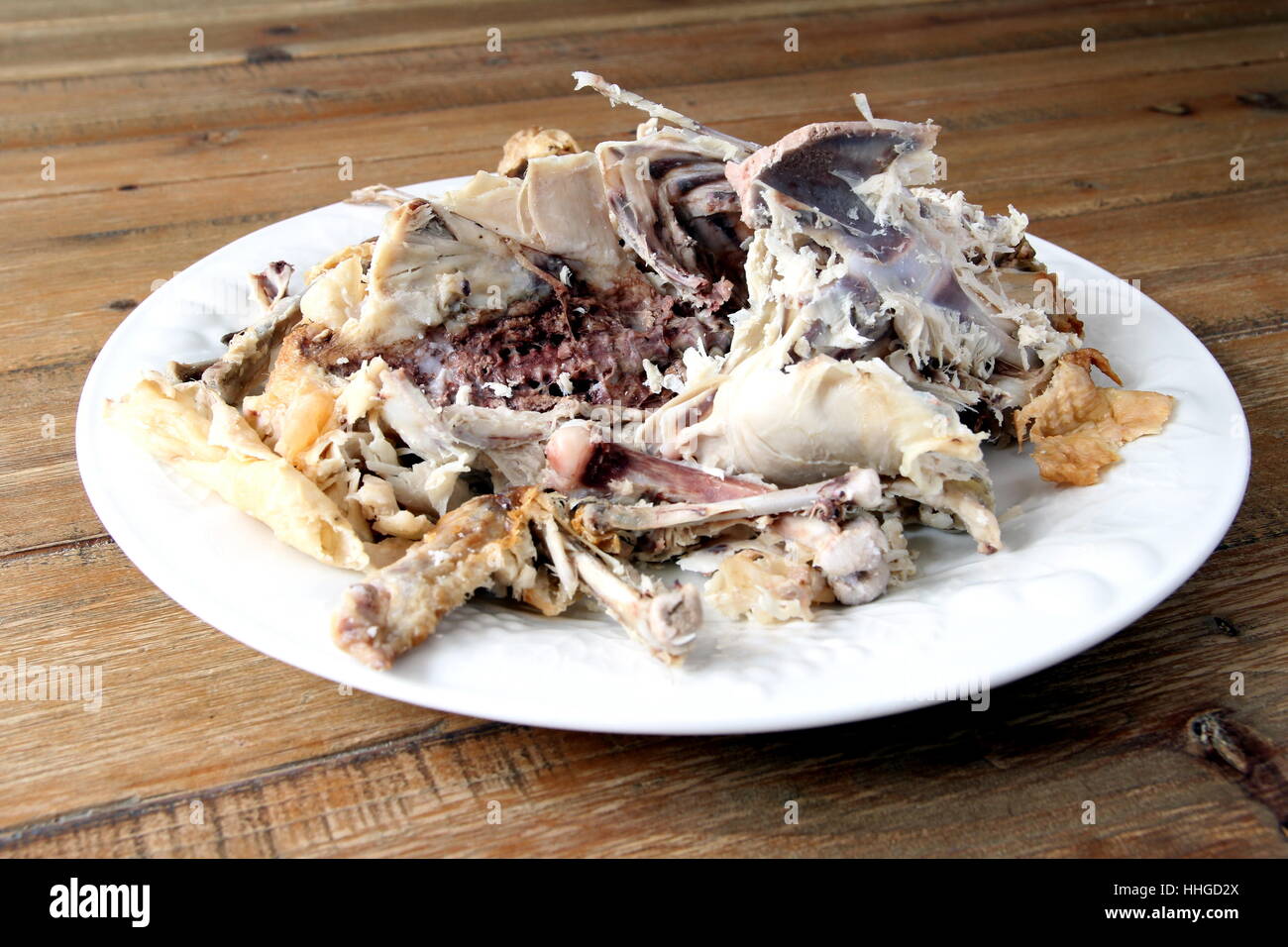 Pollo arrosto carcassa rimane su una piastra su un tavolo di legno Foto Stock