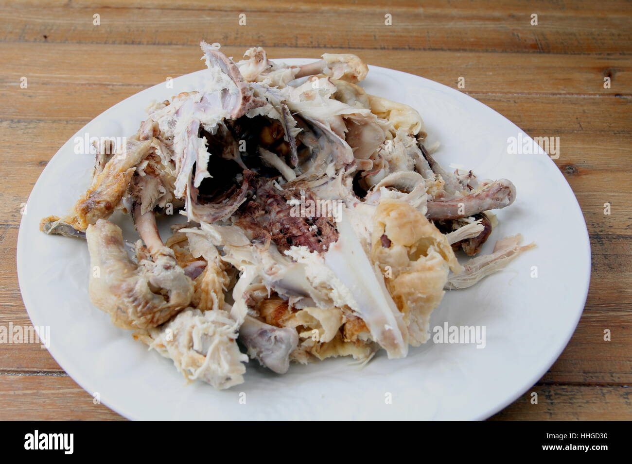 Pollo arrosto carcassa rimane su una piastra su un tavolo di legno Foto Stock