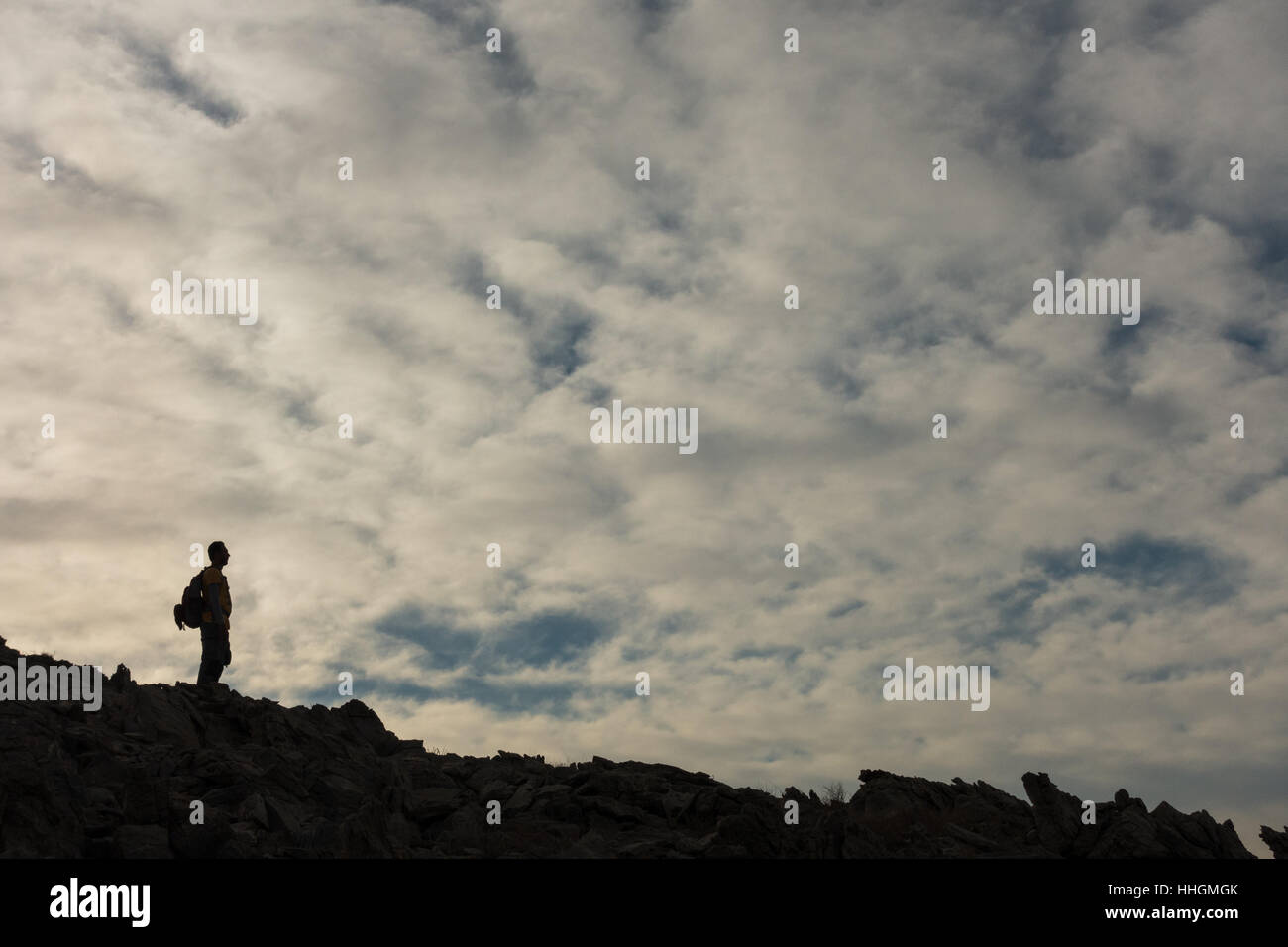 Un uomo di godere della vista delle nubi sopra la montagna bianca, Muscat Oman Foto Stock