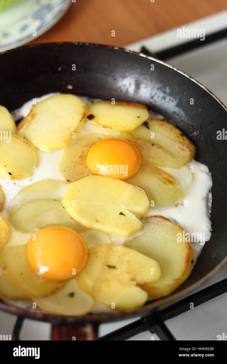 Facendo parte soleggiata fino le uova con patate fritte Foto Stock