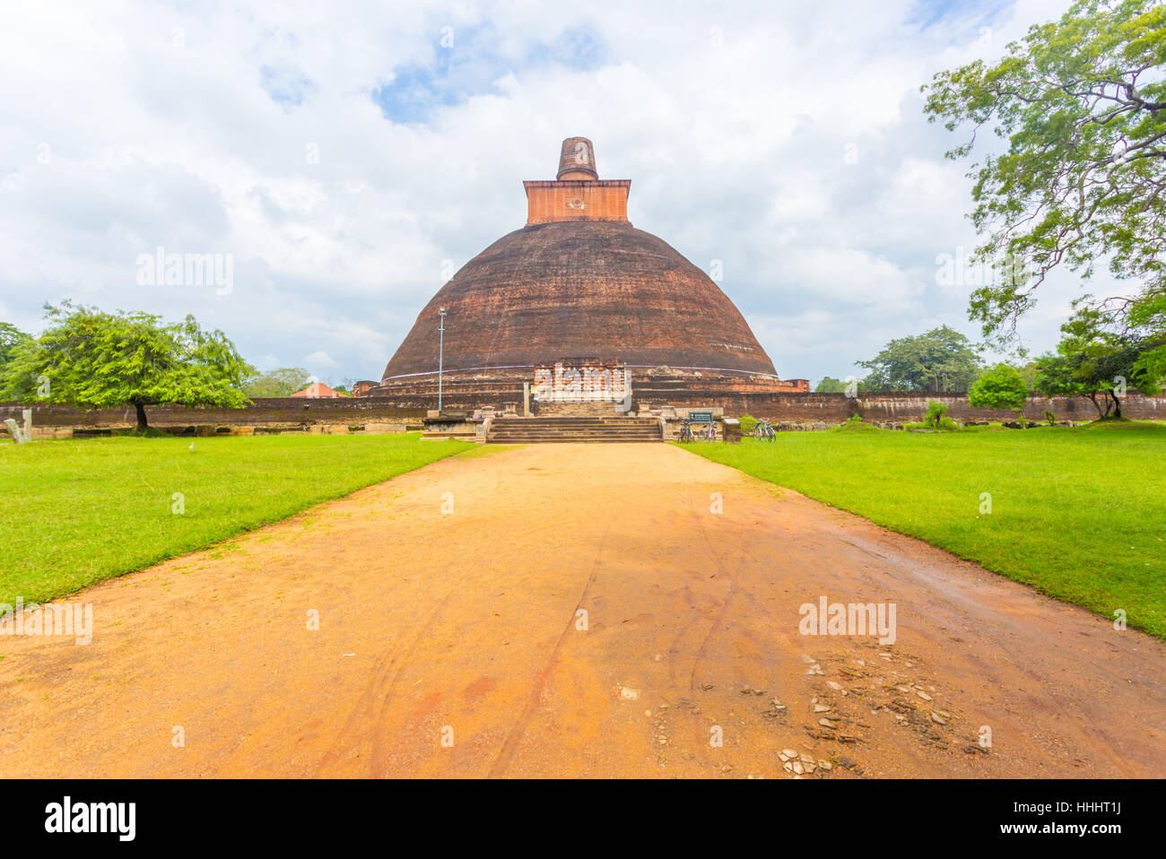 Strada sterrata per centrata Jetavanaramaya Dagoba o stupa rovine su una bella giornata in Campidoglio antico di Anuradhapura Foto Stock