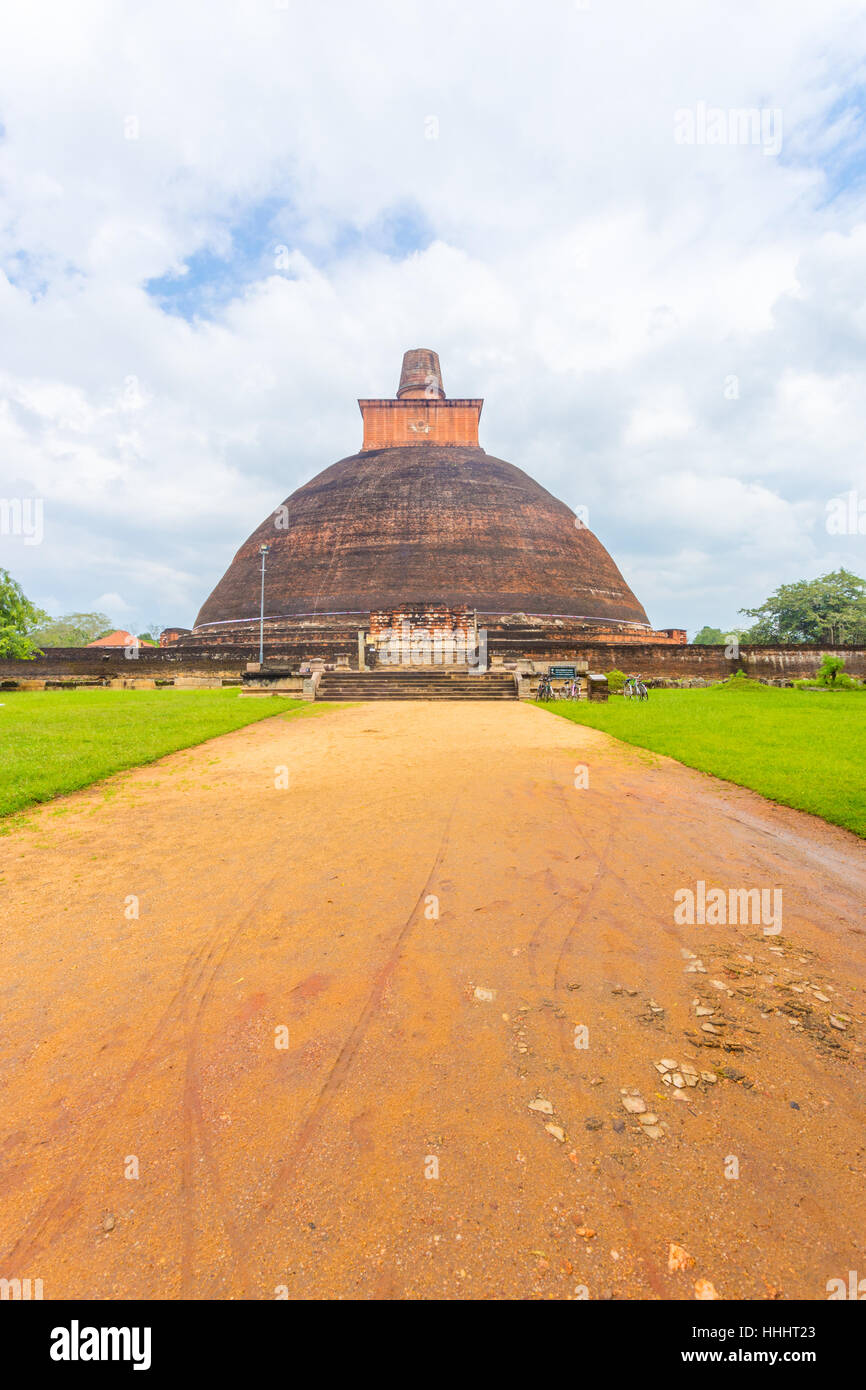Strada sterrata per centrata Jetavanaramaya Dagoba o stupa rovine su una bella giornata in Campidoglio antico di Anuradhapura Foto Stock