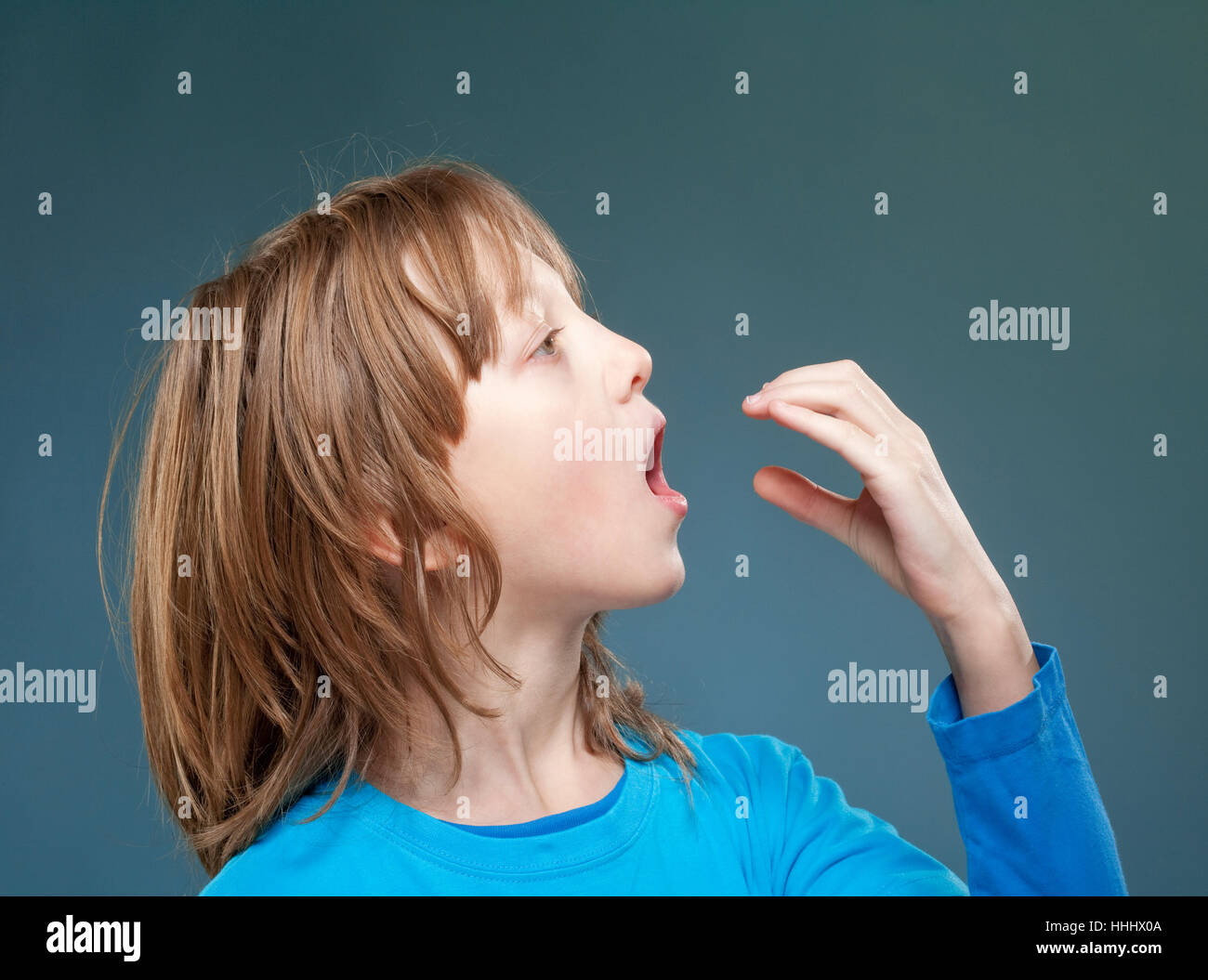 Ragazzo che finge di essere mangiare qualcosa di invisibile. Foto Stock