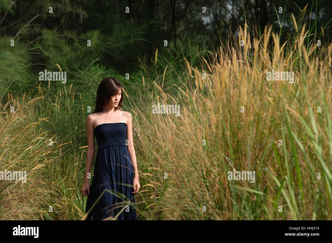 Donna che cammina in erba lunga Foto Stock