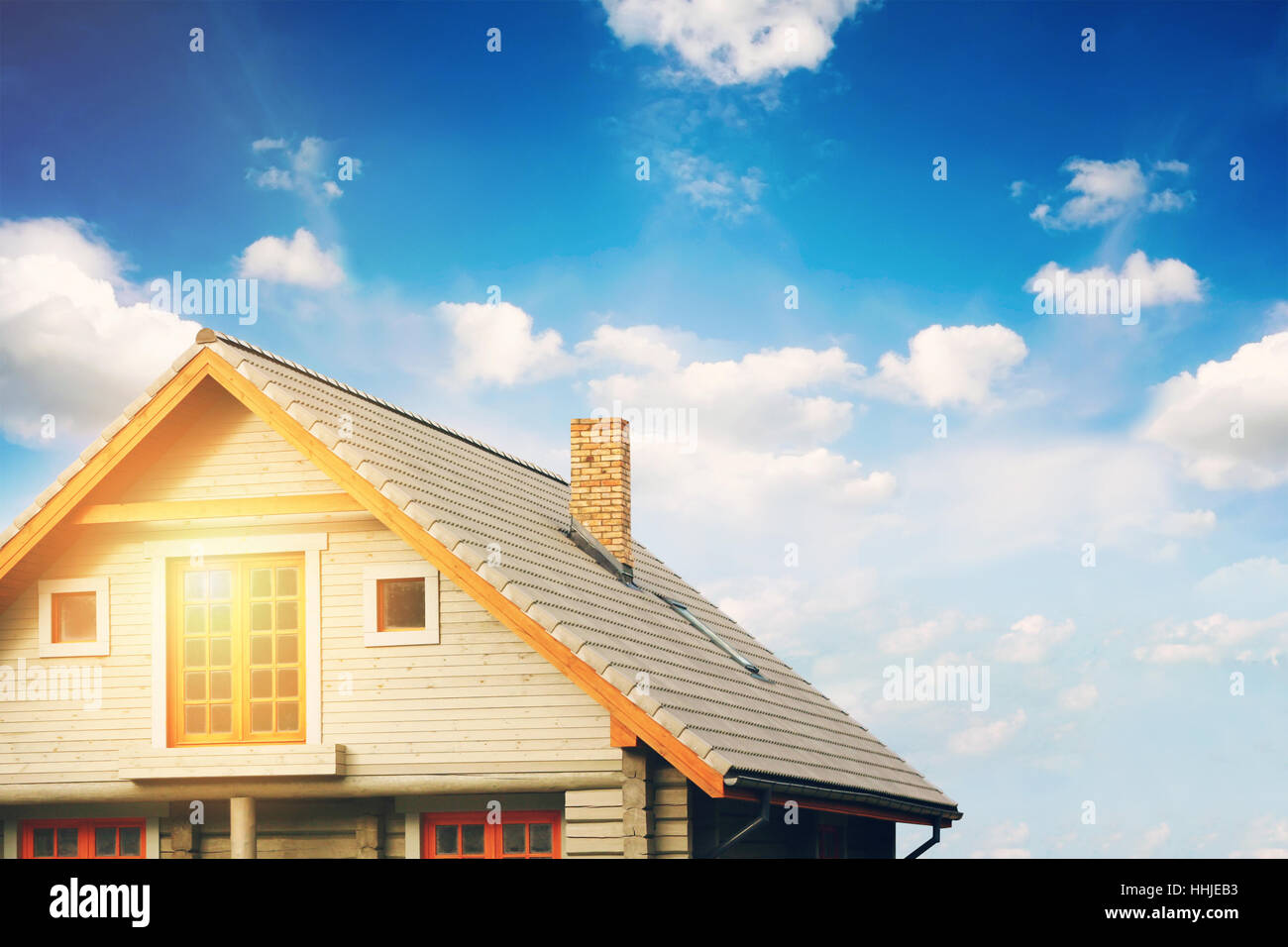 Lodge di registro con il grigio tetto di tegole contro il cielo blu Foto Stock