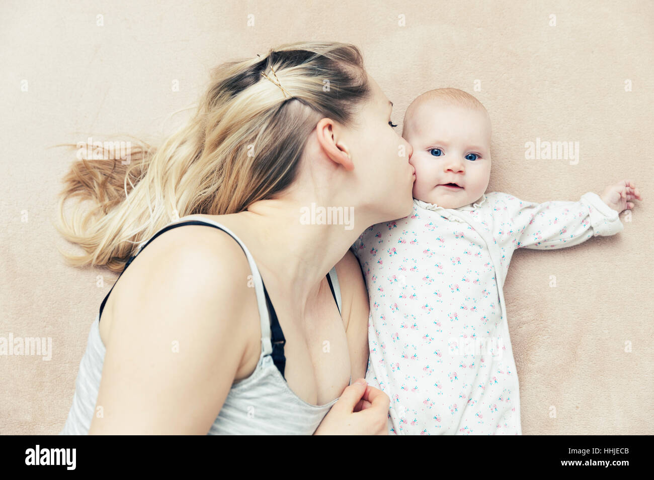 Madre baciare il suo bambino bambina Foto Stock