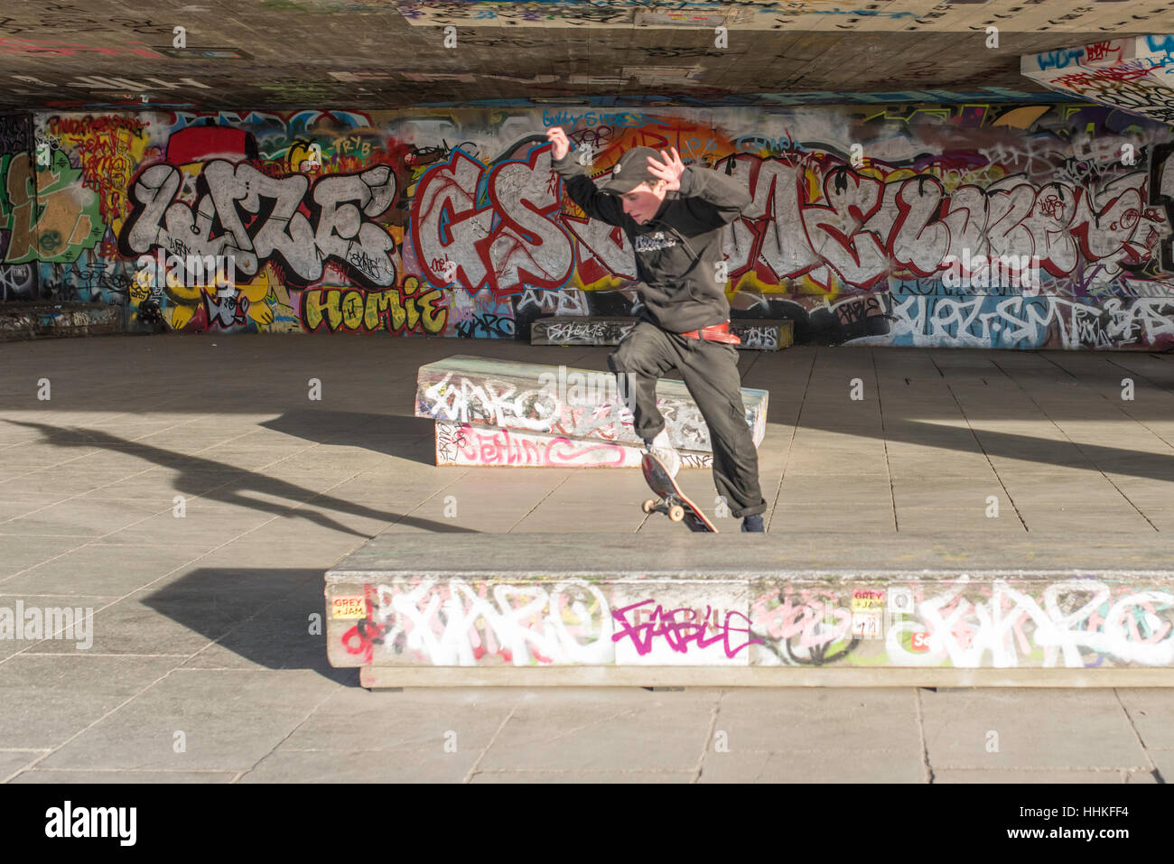 Un guidatore di skateboard di eseguire un salto nel sottopassaggio del South Bank di Londra. Foto Stock
