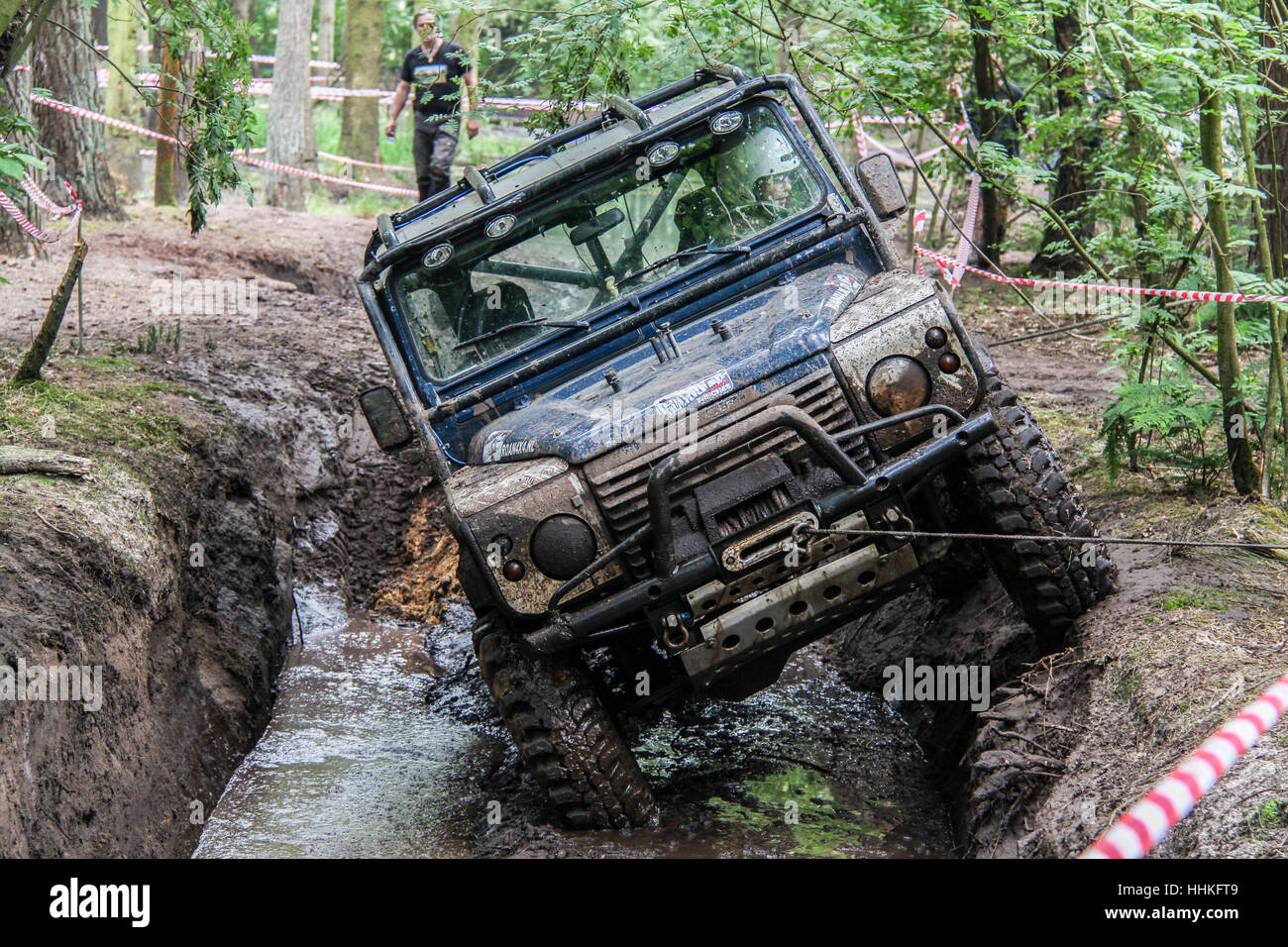 Blue 4x4 Land Rover Defender 90 durante il fangoso 4x4 off-road challenge Foto Stock