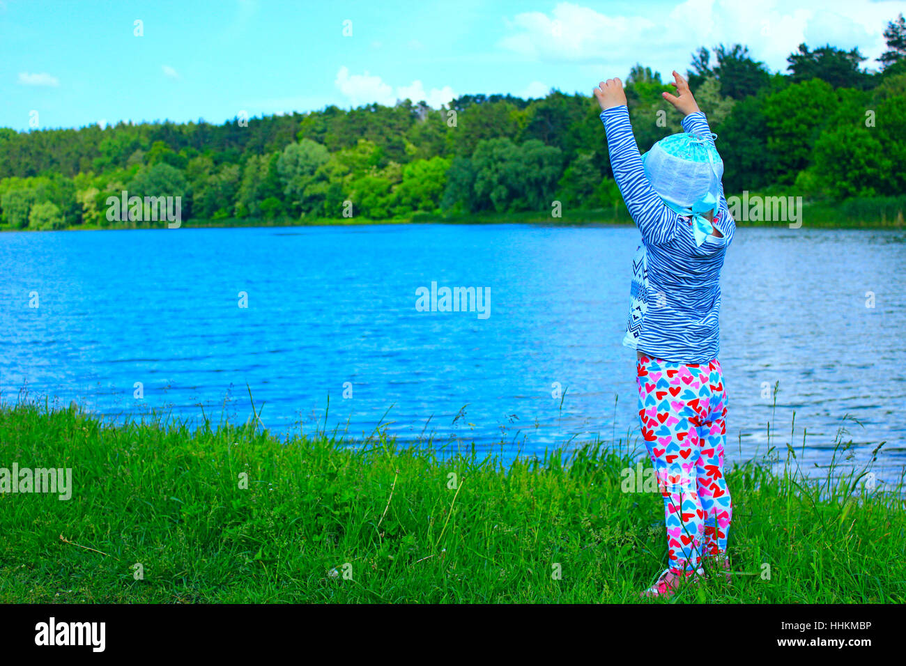 Il bambino è felice vicino al fiume nella foresta Foto Stock