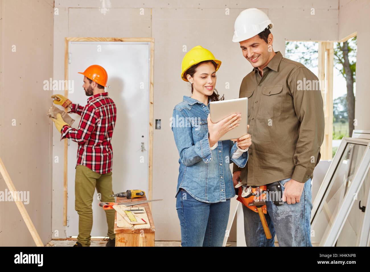 Gli architetti e gli artigiani rinnovando nel lavoro di squadra a sito in costruzione Foto Stock