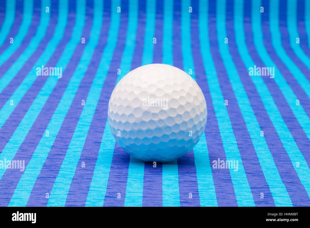 White pallina da golf su strisce blu tovaglia. Foto Stock