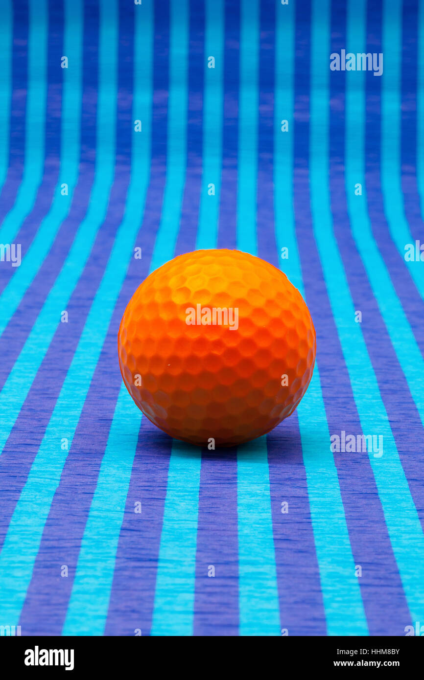 Orange pallina da golf su strisce blu tovaglia. Foto Stock