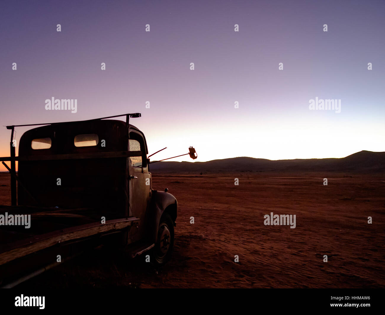 Vecchio arrugginito relitto di un carrello Fargo in inizio di mattina di luce, in un deserto impostazione nell'outback australiano Foto Stock