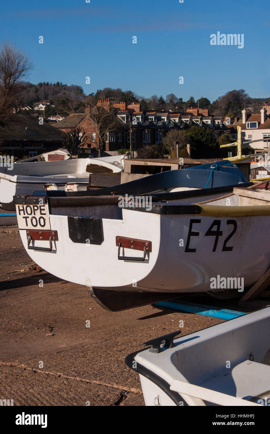 Barche da pesca cazzate fino sul prosciutto a Sidmouth lungomare, con città cottages dietro. Foto Stock