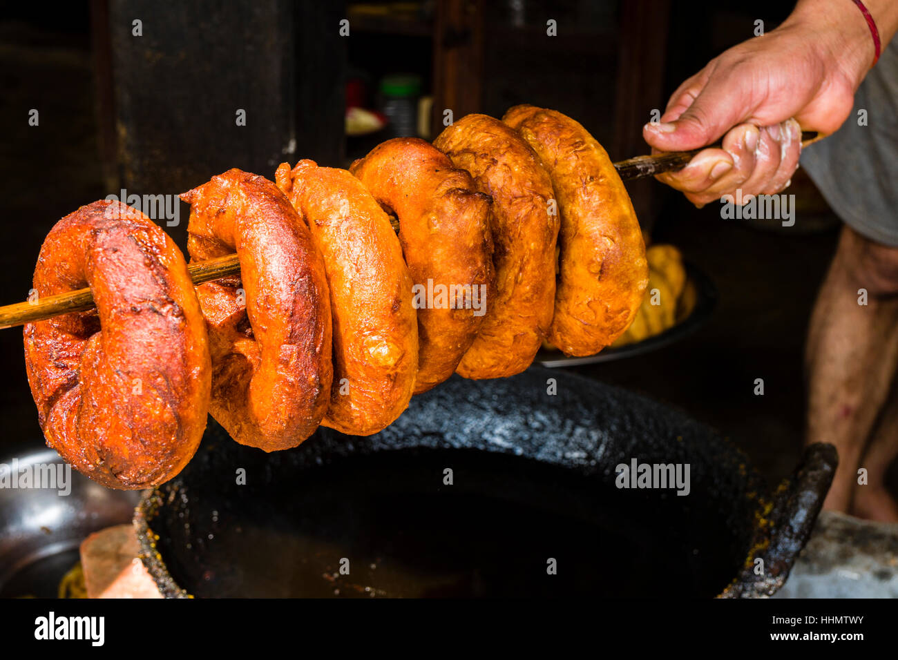 Mano azienda ciambelle fresche su un bastone di legno, Bandipur, Tanahun District, Nepal Foto Stock