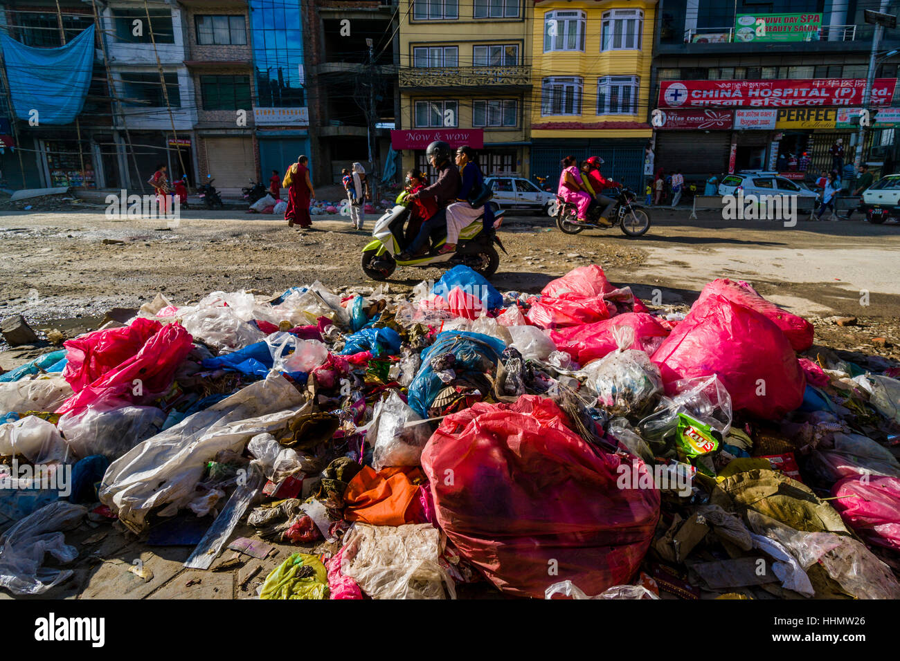 Garbage impilati accanto alla strada trafficata in Bouda sobborgo, Kathmandu, Nepal Foto Stock