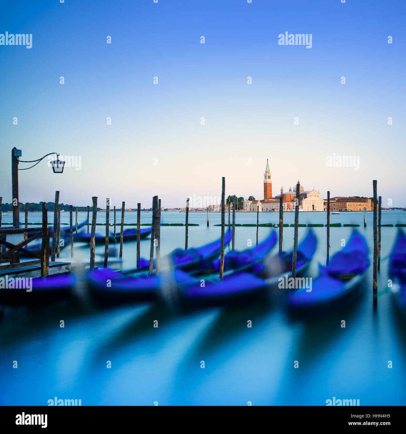 Venezia, gondole o gondole su un blu crepuscolo al tramonto e la chiesa di San Giorgio Maggiore punto di riferimento sullo sfondo. L'Italia, l'Europa. Foto Stock