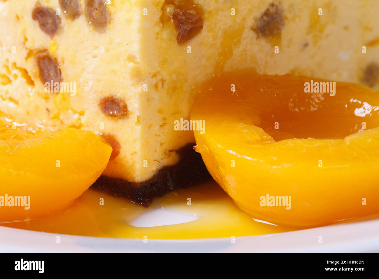 Formaggio casseruola con uvetta e pesche su una piastra bianca orizzontale macro Foto Stock