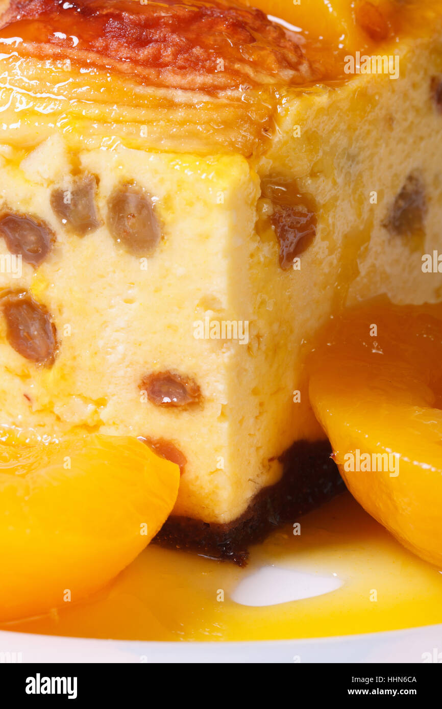 Formaggio casseruola con uvetta e pesche su una piastra bianca verticale macro Foto Stock