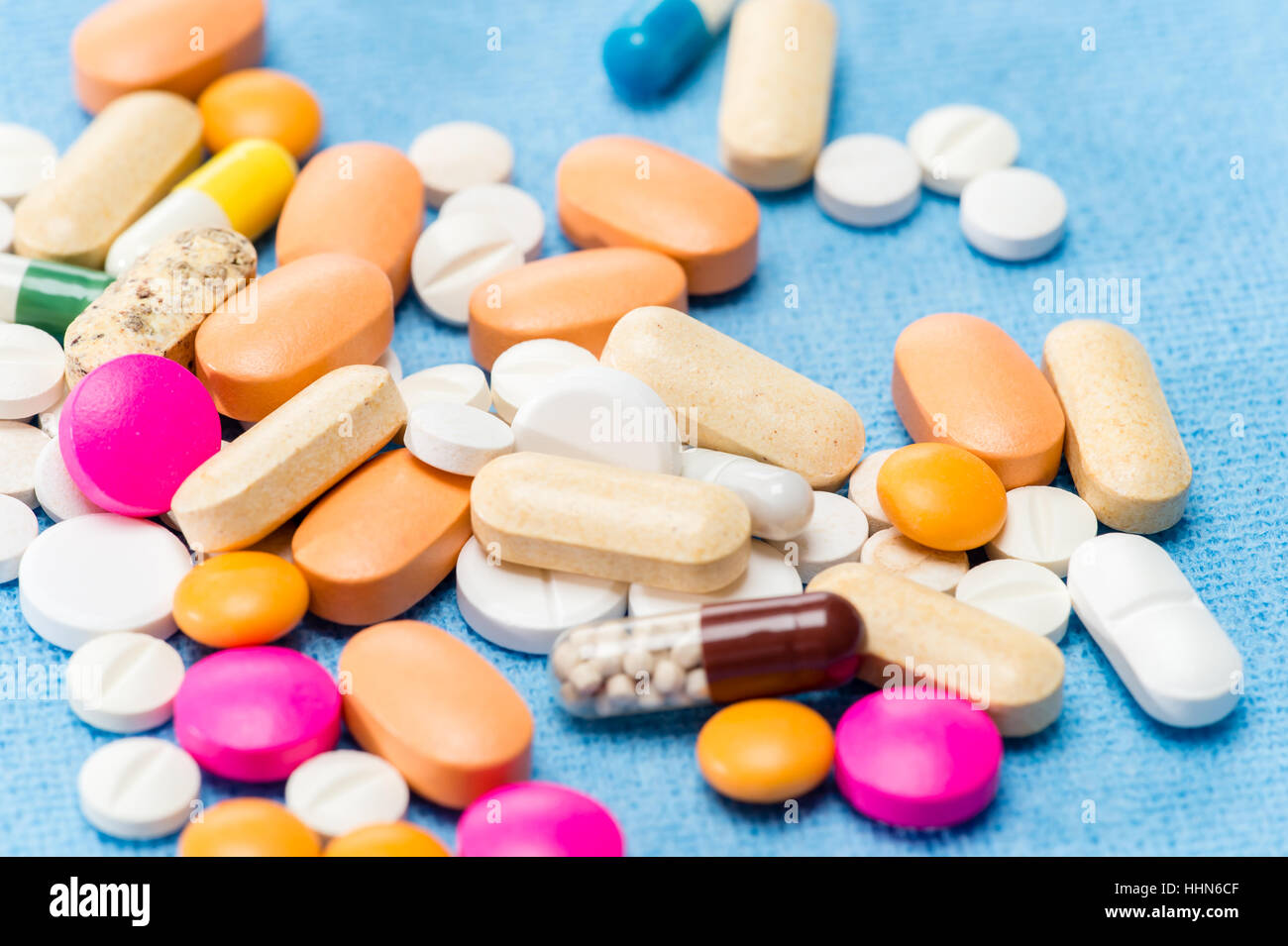 Colore medicamento pillole capsule versato sui medici panno blu Foto Stock