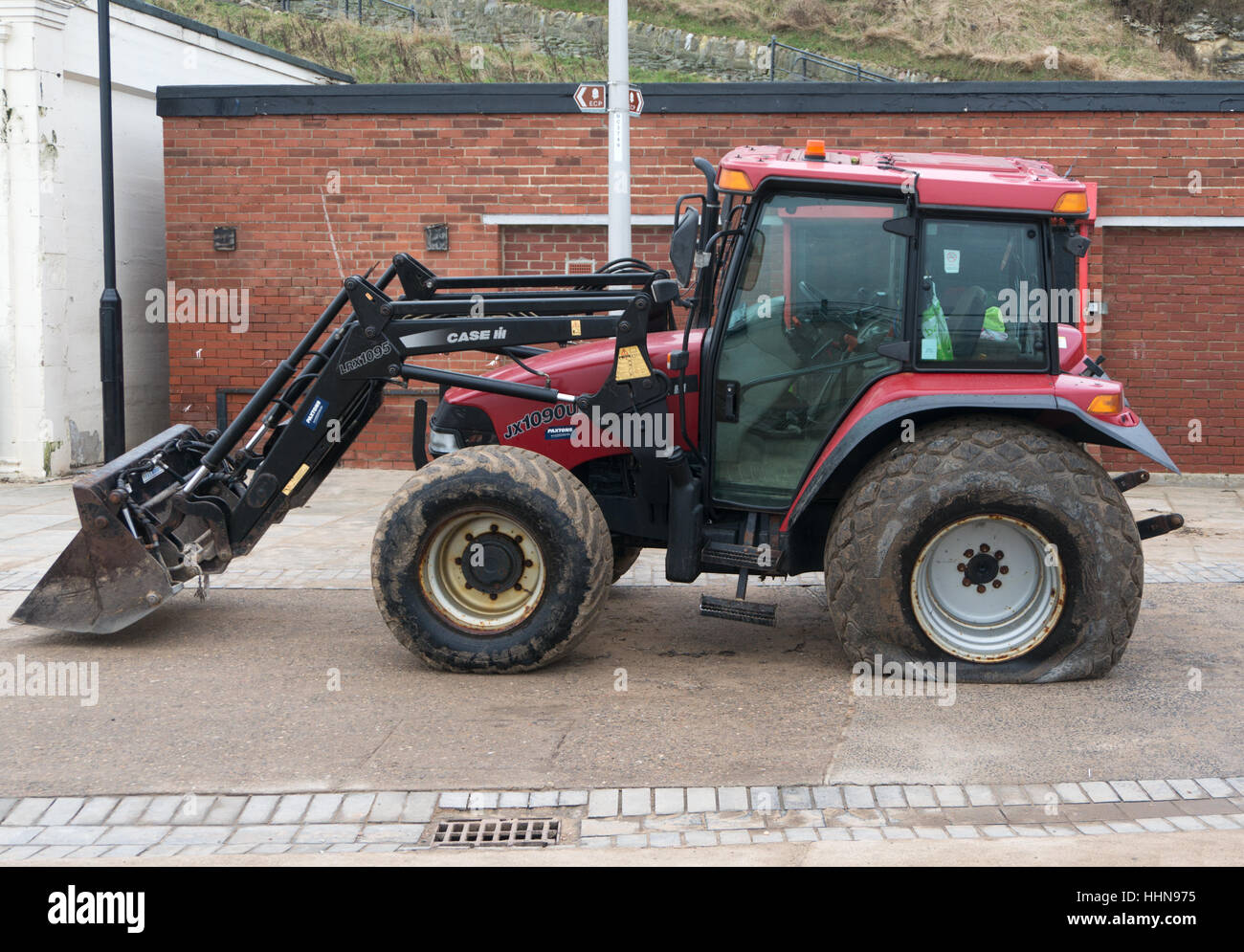 Trattore Case con un pneumatico sgonfio, Roker, Sunderland, England, Regno Unito Foto Stock