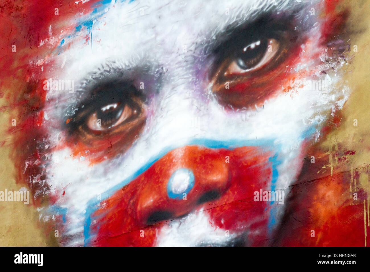 Stile africano dipinto di rosso voodoo-di fronte scary clown graffiti, Manchester, Regno Unito Foto Stock