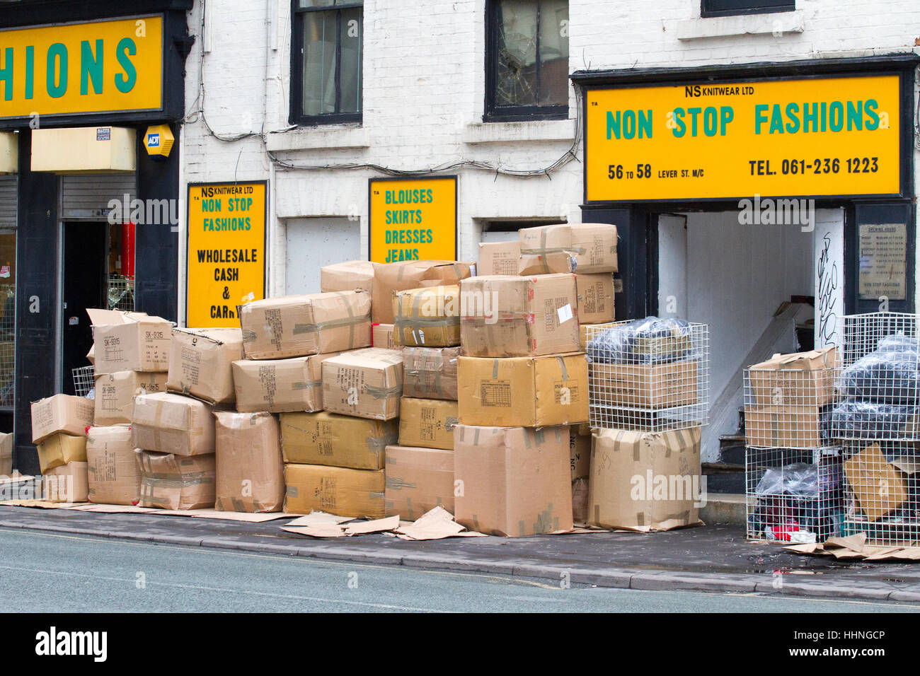 Impilate le scatole di cartone sul marciapiede esterno Non Stop Mode, commercio all'ingrosso cash and carry, Manchester, Regno Unito Foto Stock