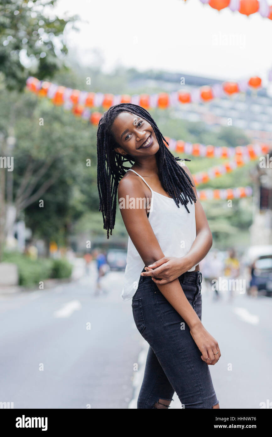 Ritratto di sorridere razza mista donna in piedi in strada Foto Stock