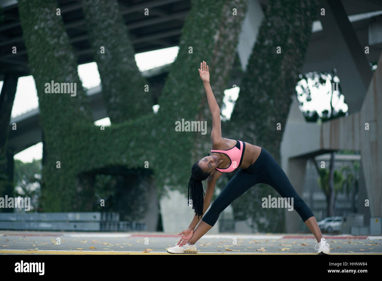 Razza mista donna stretching sotto il ponte Foto Stock