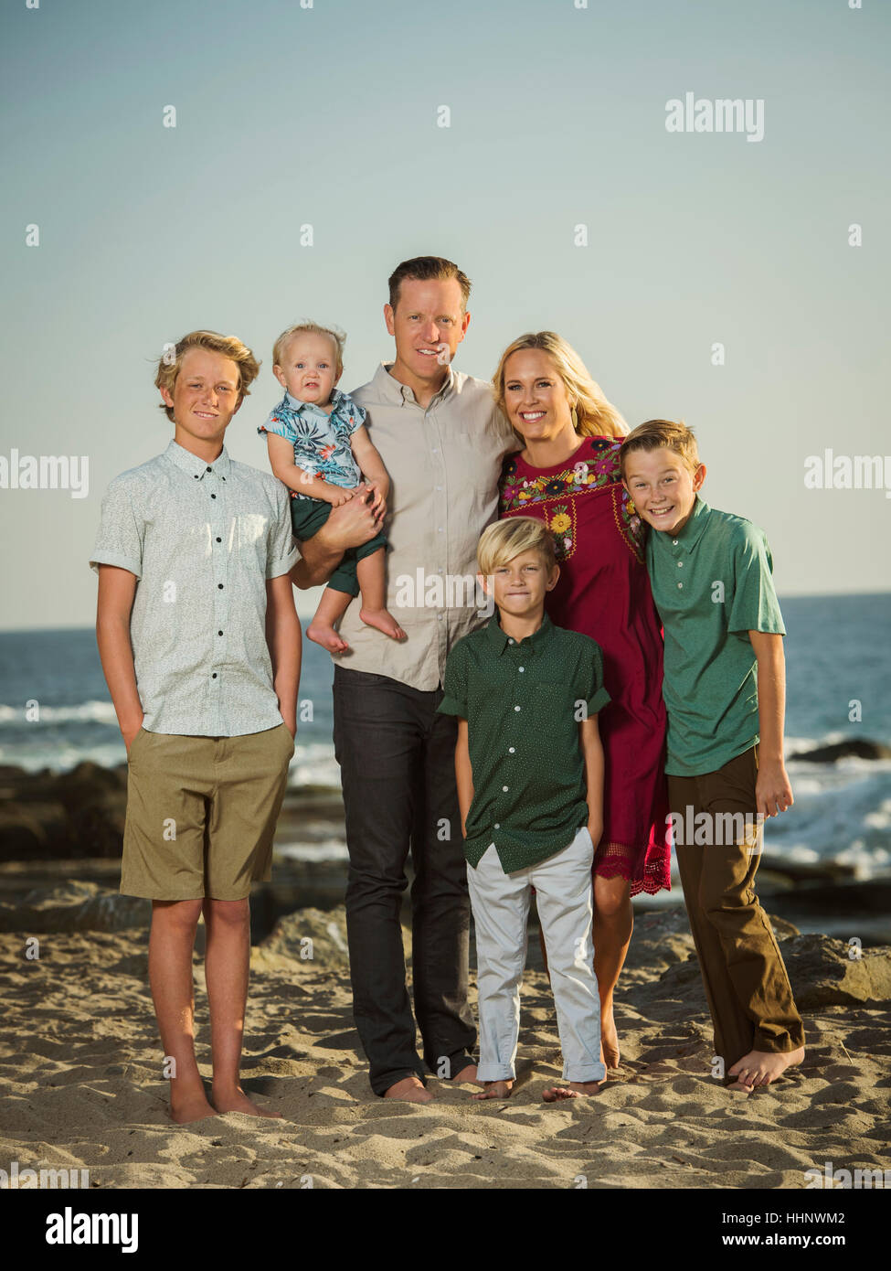 Famiglia caucasica in posa sulla spiaggia Foto Stock