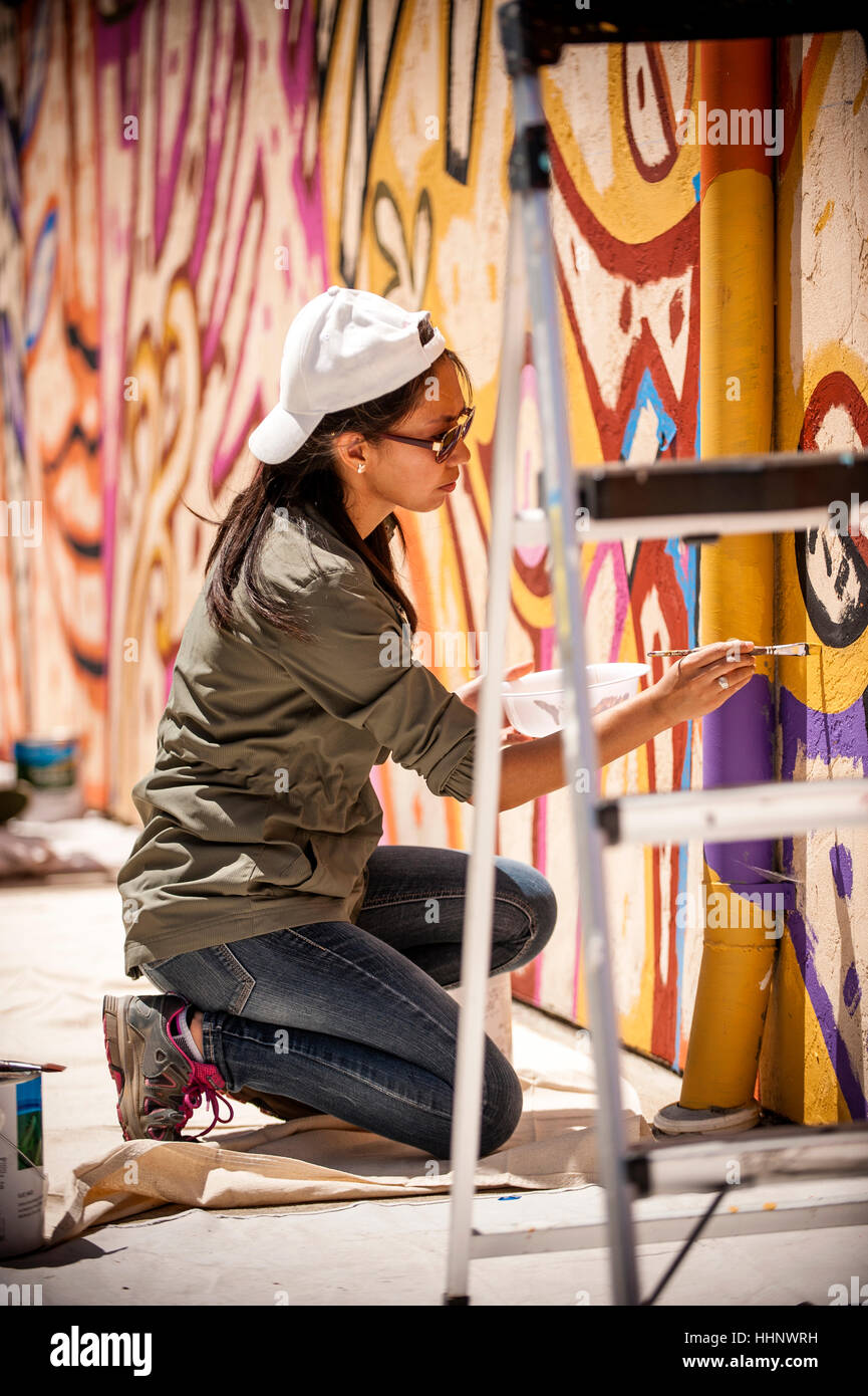 Donna inginocchiata sul tarp pittura murale sulla parete Foto Stock
