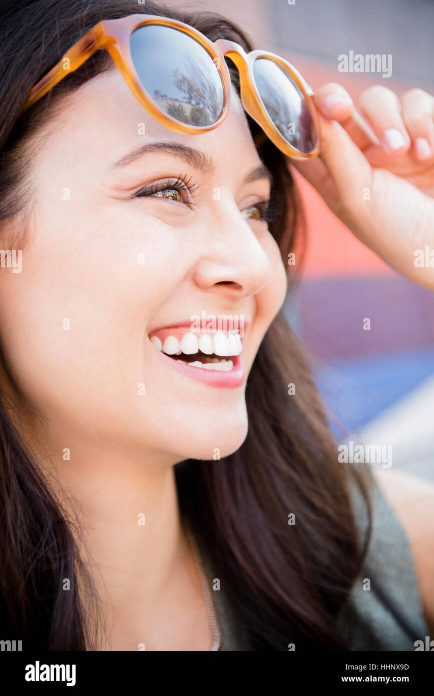 Sorridente donna Thai occhiali da sole di sollevamento Foto Stock
