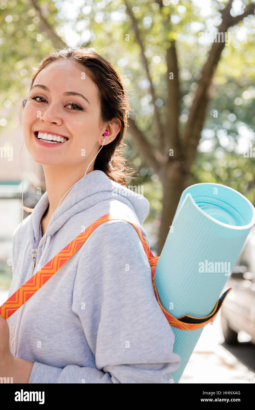 Donna Thai in posa nella città portando esercizio mat Foto Stock