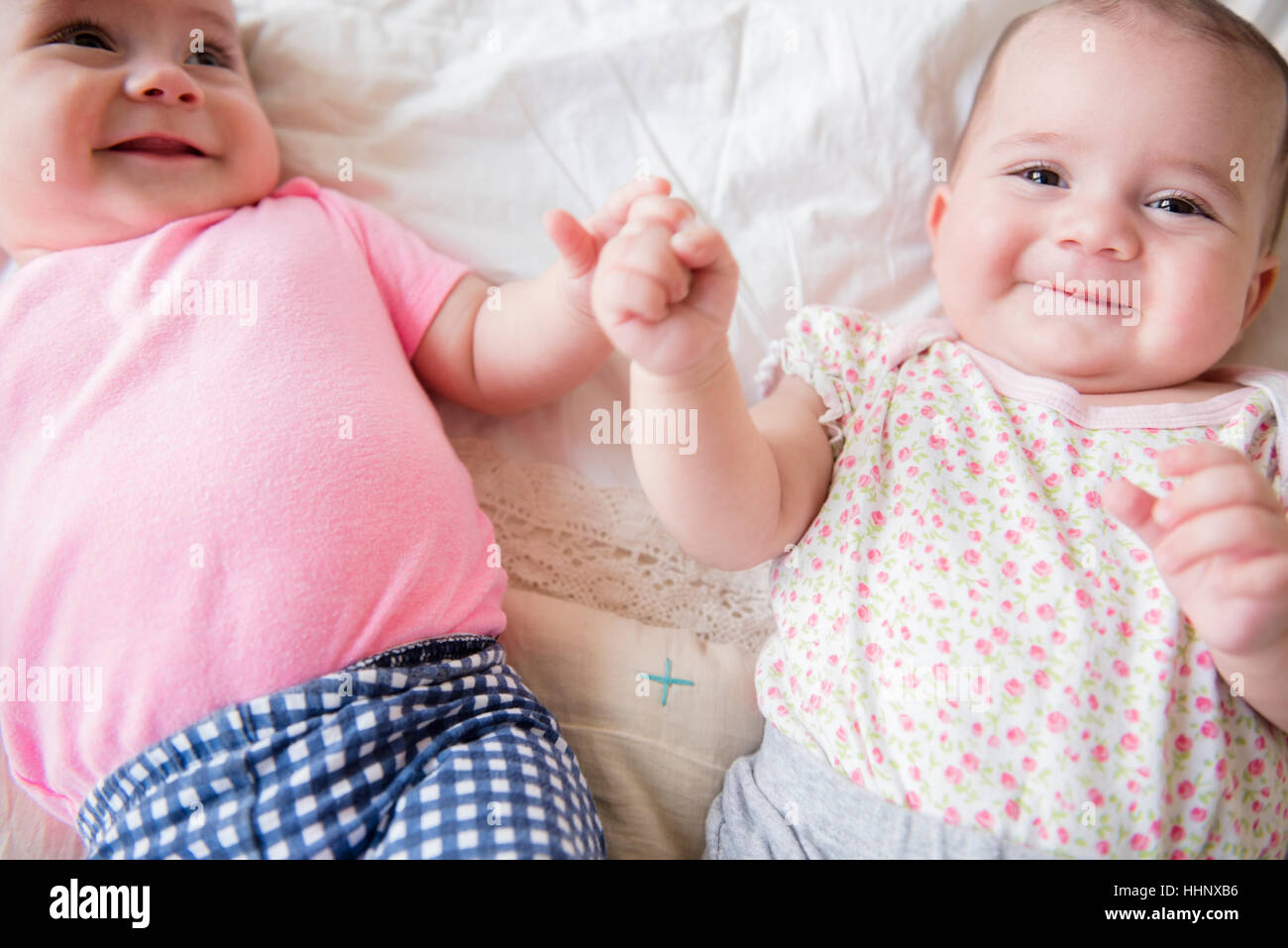 Twin caucasica baby ragazze sorridenti sul letto Foto Stock