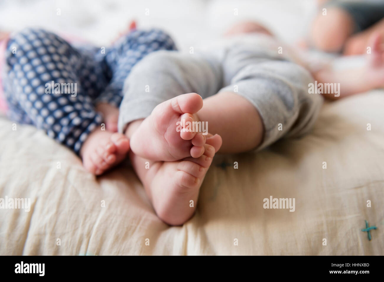 Piedi di soggetti di razza caucasica twin baby ragazze posa sul letto Foto Stock
