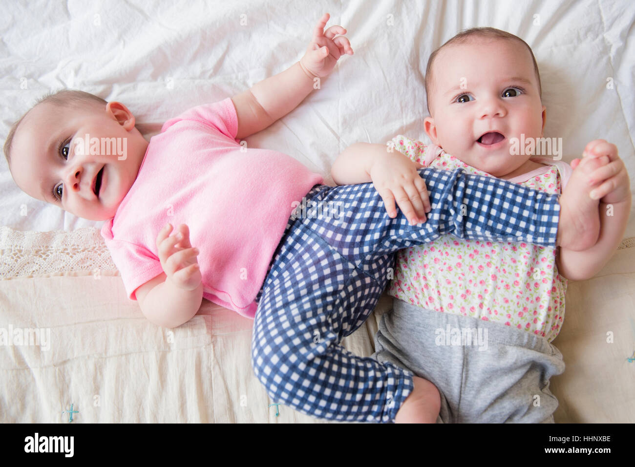 Twin caucasica baby ragazze giocando sul letto Foto Stock