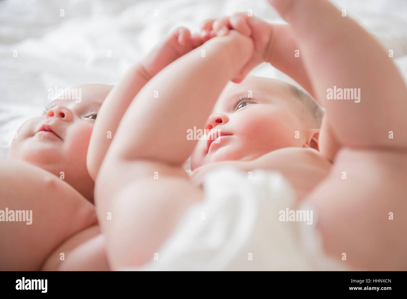 Twin caucasica baby ragazze posa sul letto Foto Stock