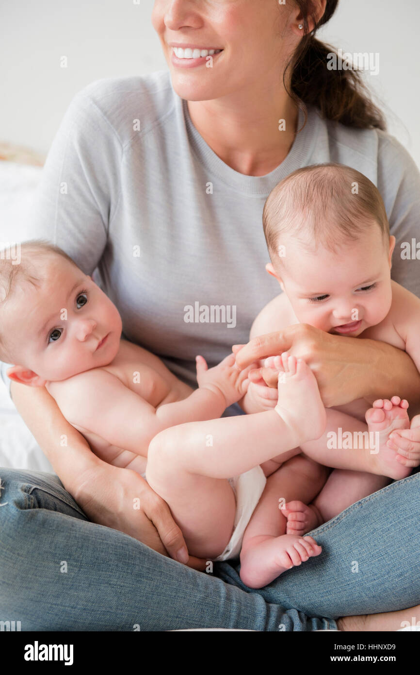 Madre caucasica holding twin baby figlie in giro Foto Stock