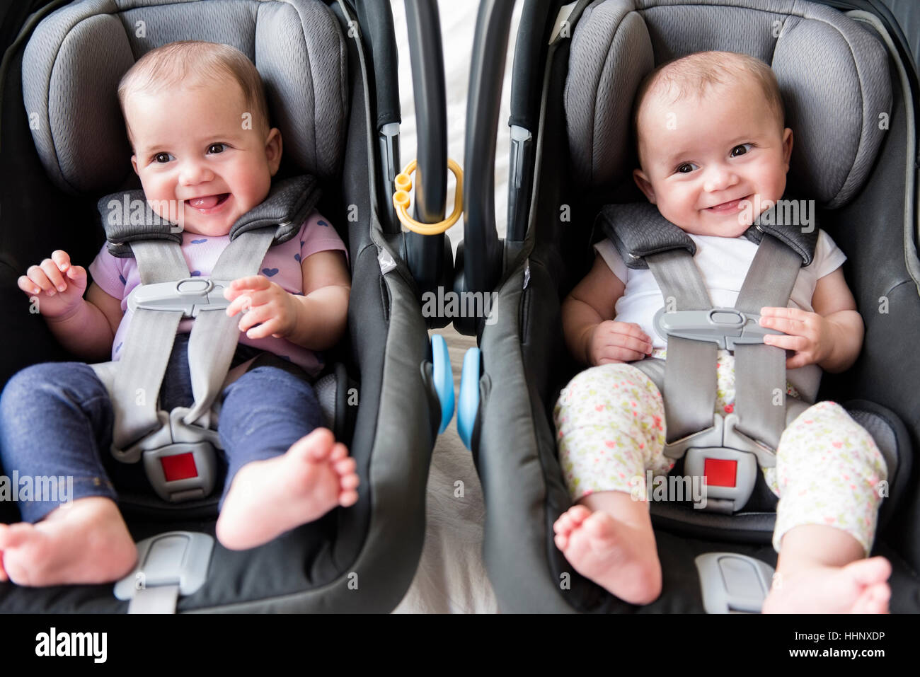 Twin caucasica baby ragazze nei sedili di automobili Foto Stock