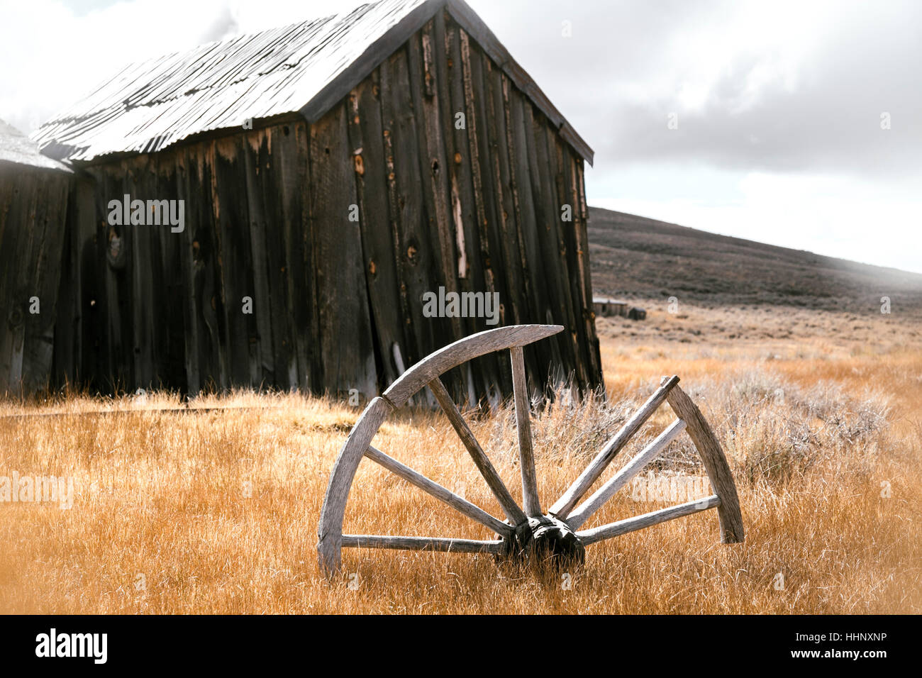 Rotto la ruota di legno in erba vicino edificio rustico Foto Stock