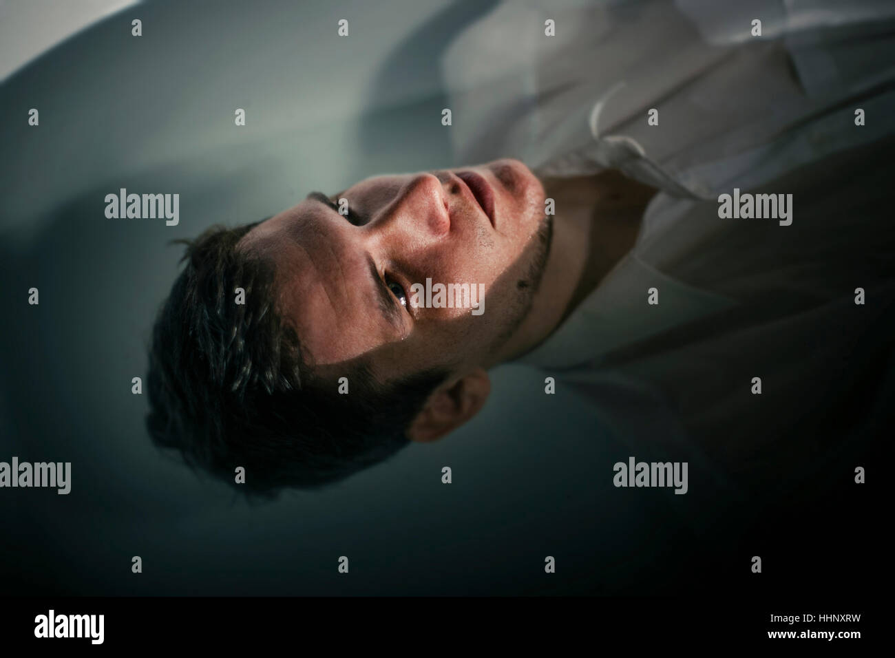 Uomo caucasico indossando shirt galleggiante nella vasca da bagno di acqua Foto Stock