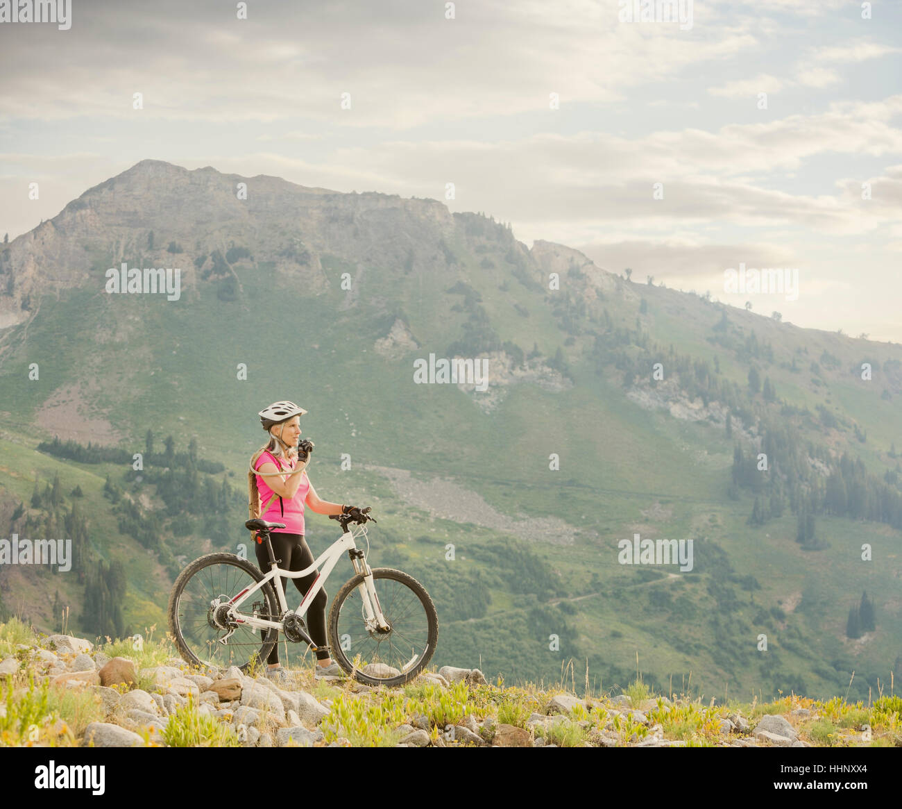 La donna caucasica con mountain bike bere da uno zaino Foto Stock