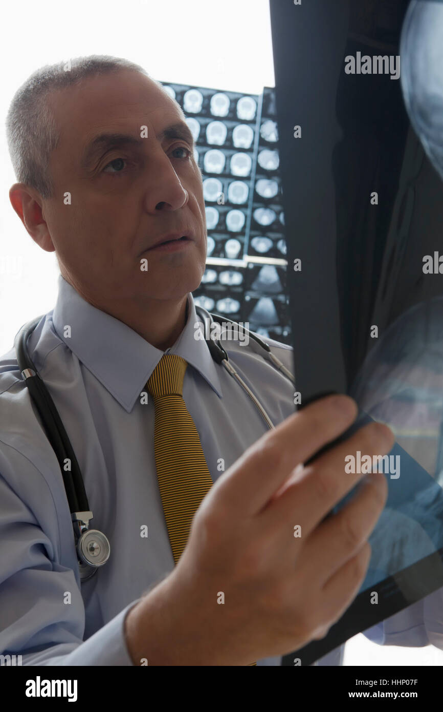 Medico di origine ispanica esaminando x-ray Foto Stock