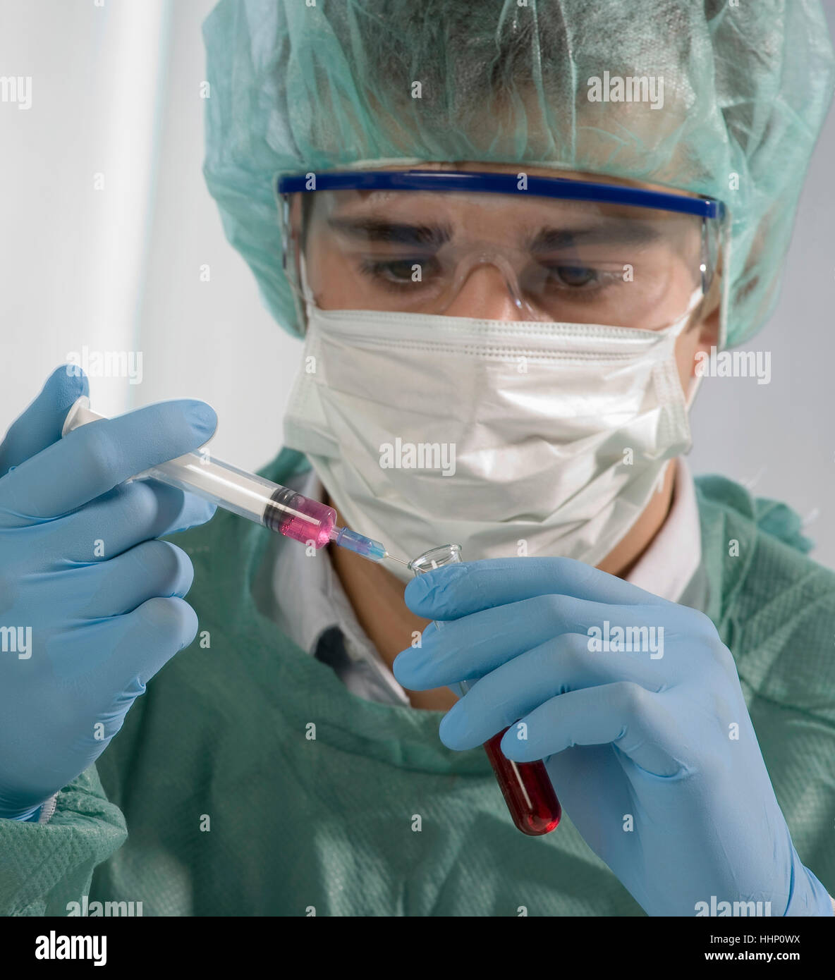Scienziato caucasica tenendo la siringa e il tubo di prova Foto Stock