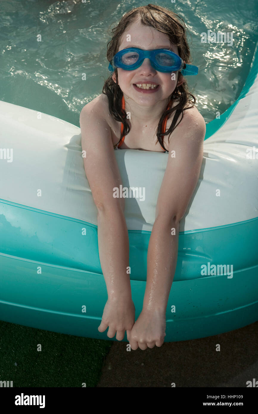 Sorridente ragazza caucasica in piscina gonfiabile Foto Stock