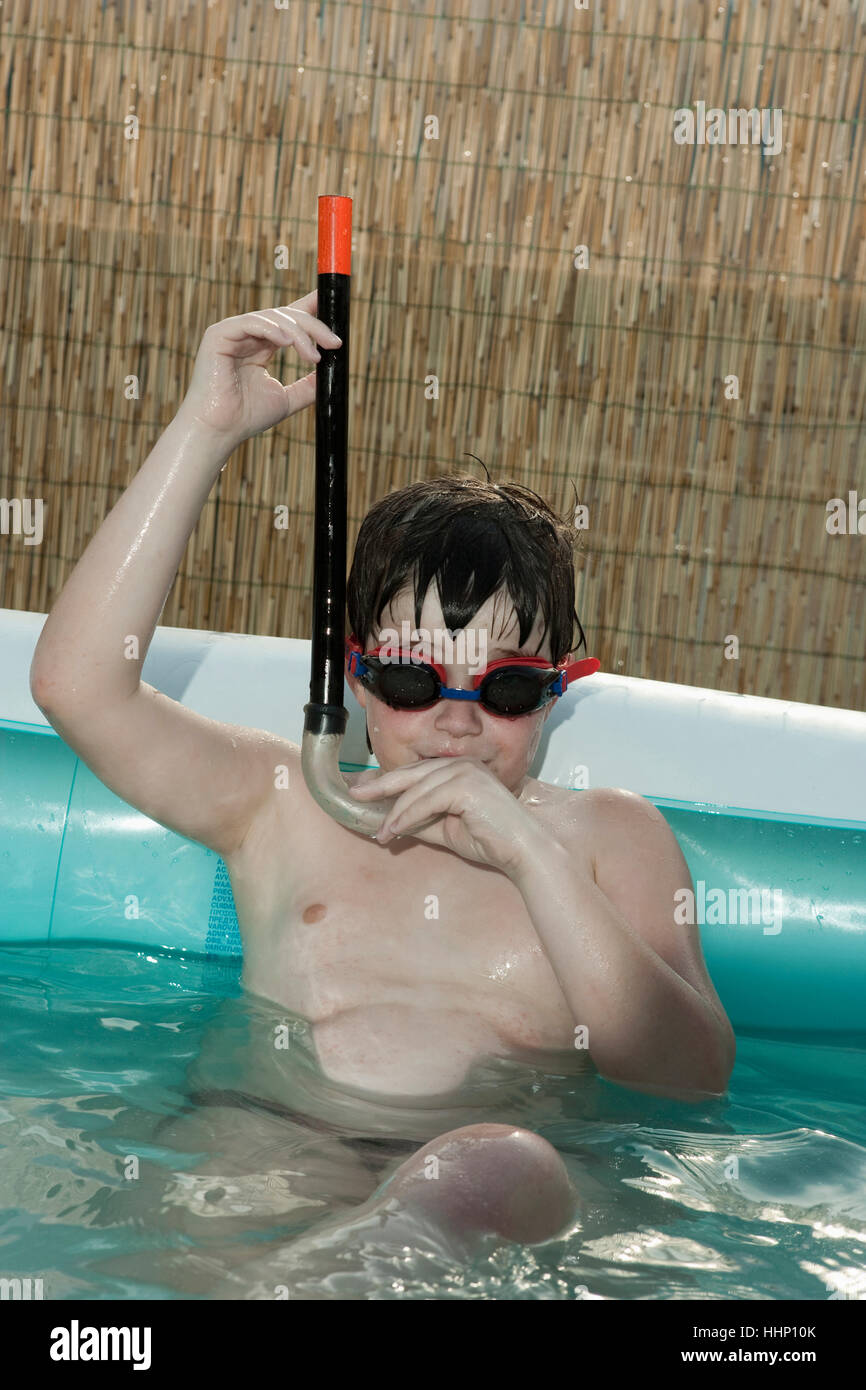 Ragazzo caucasico indossando snorkel in piscina gonfiabile Foto Stock
